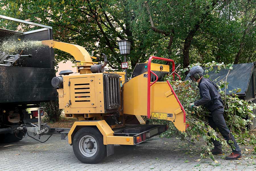 man putting branches into wood chipper carthage ny